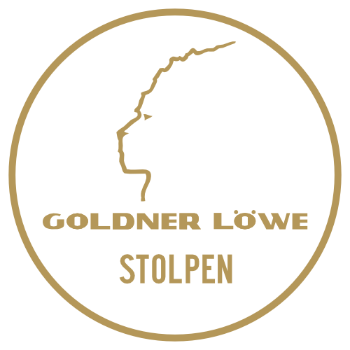 Ein goldenes, kreisförmiges Logo mit dem Umriss eines Löwenprofils über dem Schriftzug HOTEL GOLDNER LÖWE und STOLPEN in Großbuchstaben auf schwarzem Hintergrund steht für das renommierte Hotel in Stolpen.